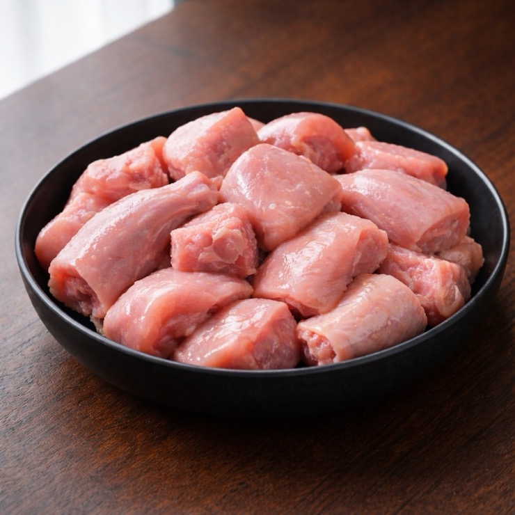 Fresh curry cut chicken pieces in a bowl